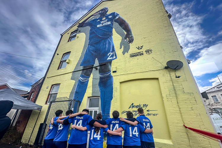 Community members in front of the Sol Bamba mural in Cardiff